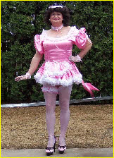 Cross-dressing pansy poses in pink French maid uniform and white stockings
